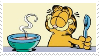 Garfield the cartoon cat sitting with a spoon and bowl of soup, eyes closed and smiling.